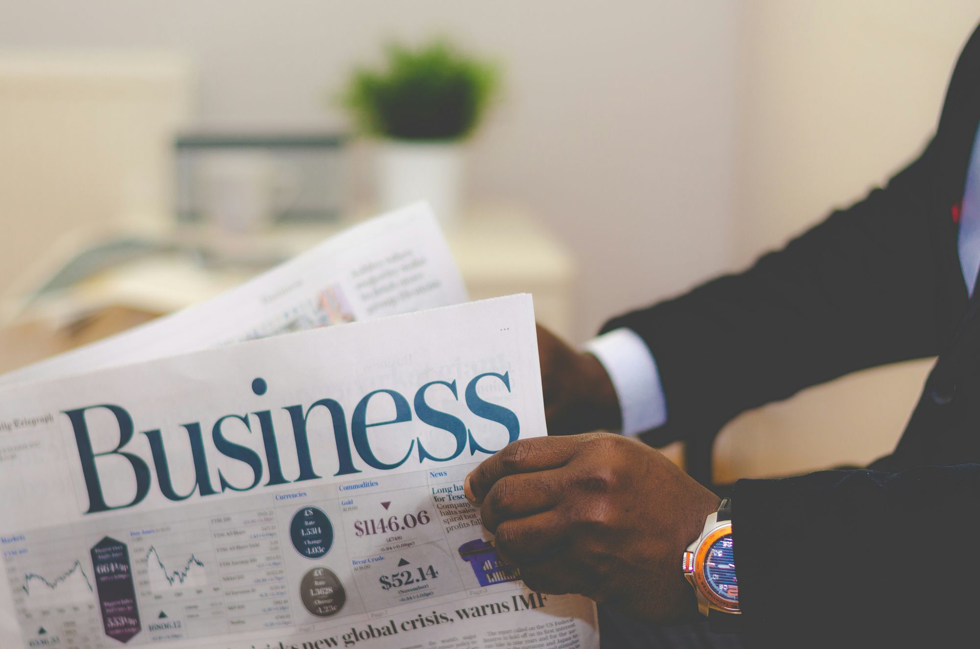 A person reading the business section of a newspaper